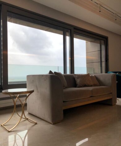 elegant grey couch next to a window with a seaview