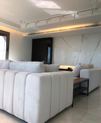 Luxurious salon with white couches and white marble-covered wall