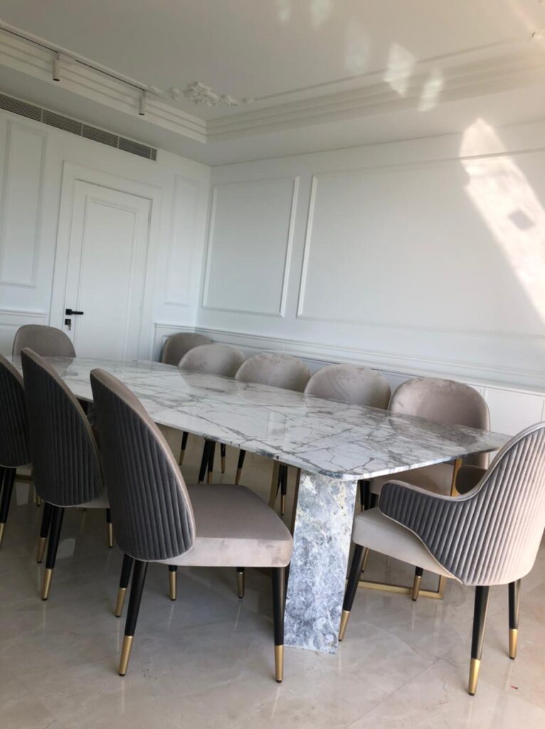 Dining room with marbled top table and 12 quilted armchairs