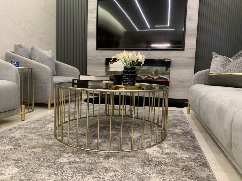 Close up on the center table in the salon. In the background is a luxurious wall design featuring a built-in chimney and TV