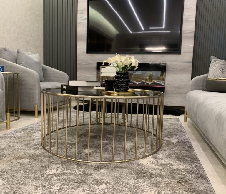 Close up on the center table in the salon. In the background is a luxurious wall design featuring a built-in chimney and TV