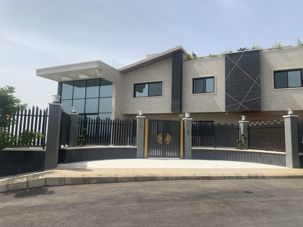 Exterior view of this luxurious 4-story villa with a glass facade on its south facing side