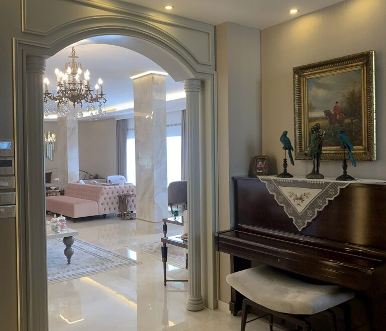 A neoclassic style arched entrance to the hall, with a Victorian era piano to the side