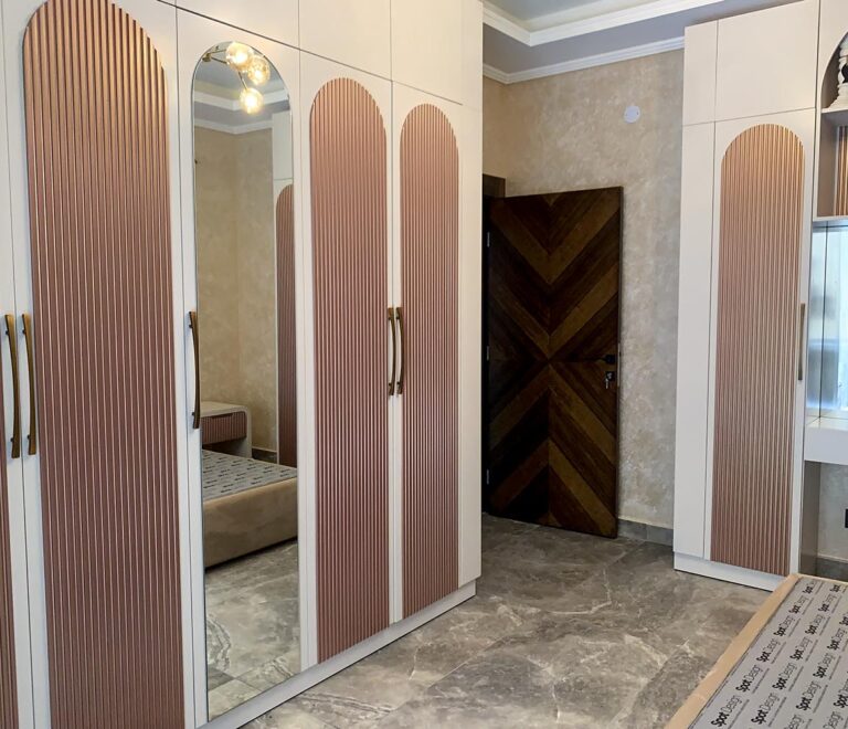 Pink and white closet with a mirror in the middle panel