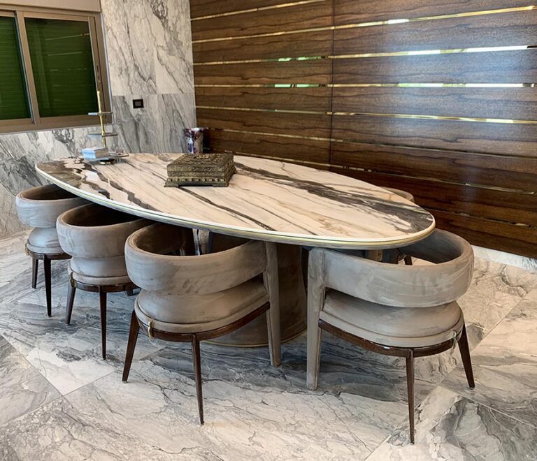 Picture showcasing the ceramic top of the dining table in addition to the velvet fabric on the dining chairs and the table frame